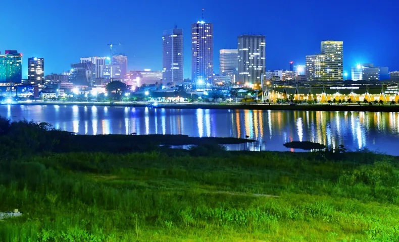 Les tours du Plateau à Abidjan, éclairées la nuit et reflétées dans la lagune.