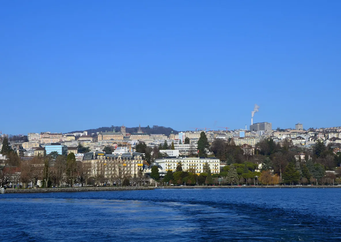 Lausanne vue depuis le lac Léman, les Alpes enneigées en arrière-plan.