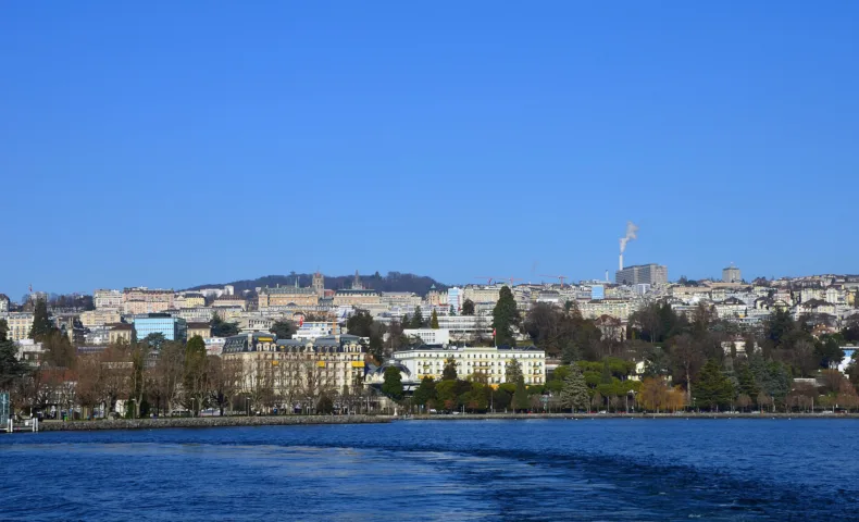 Lausanne vue depuis le lac Léman, les Alpes enneigées en arrière-plan.