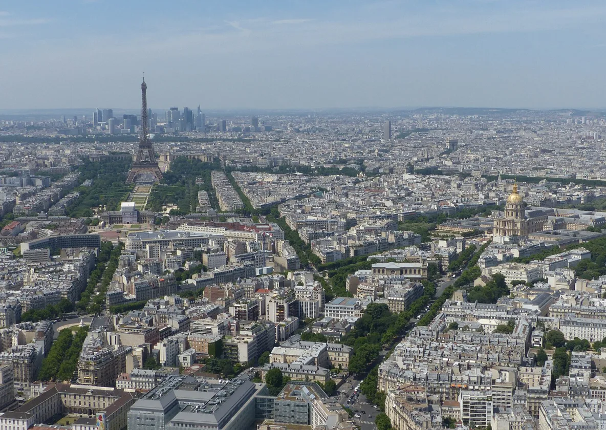 Paris en plein jour vu de haut, la tour Eiffel et La Défense à l’horizon.