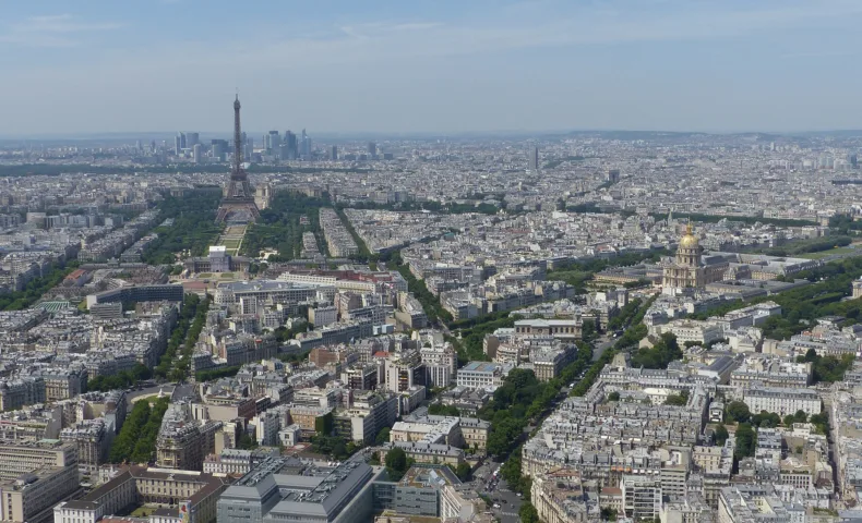 Paris en plein jour vu de haut, la tour Eiffel et La Défense à l’horizon.